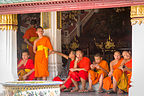 Young Buddhist monks playing with their material possessions Young Buddhist monks playing with their material possessions